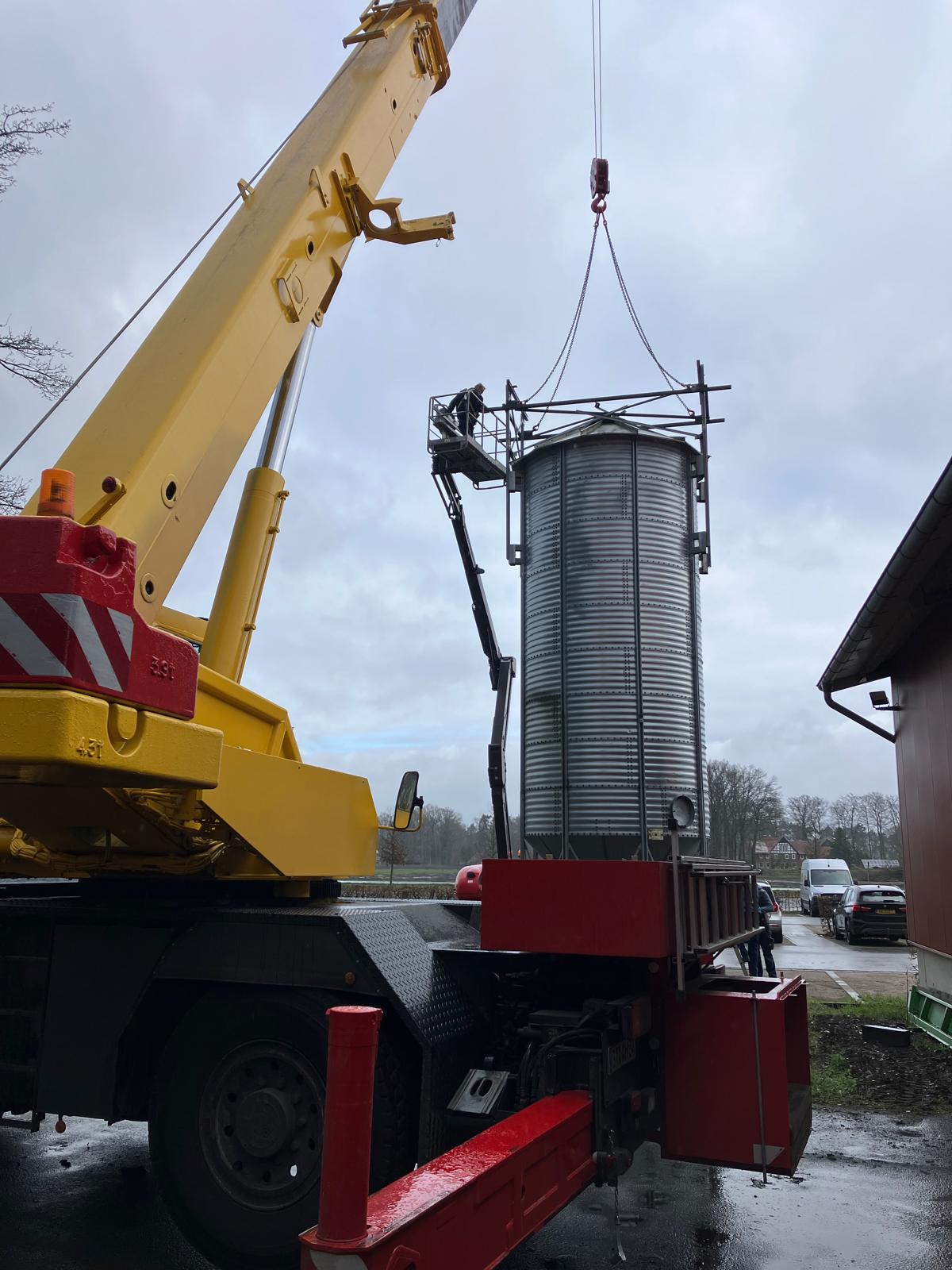 Zu sehen ist die Montage eines Silos mit einem Kran auf spezielle Anschlagpunkte.